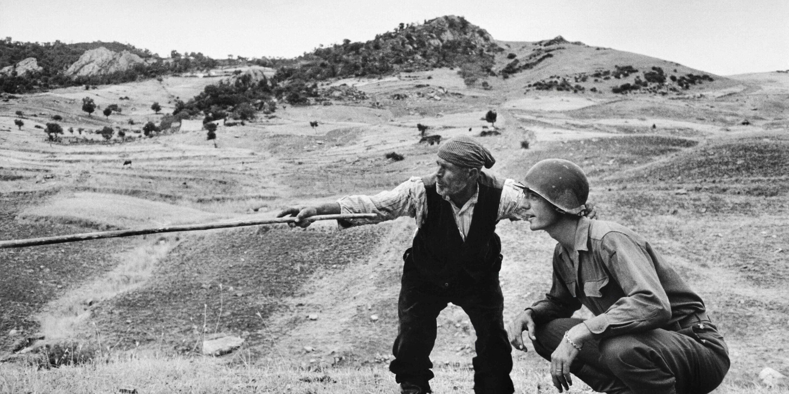 A-sicilian-peasant-telling-an-American-officer-which-way-the-Germans-had-gone-near-Troina-Italy-August-1943.-Robert-Capa_International-Center-of-Photography_Magnum-Photos