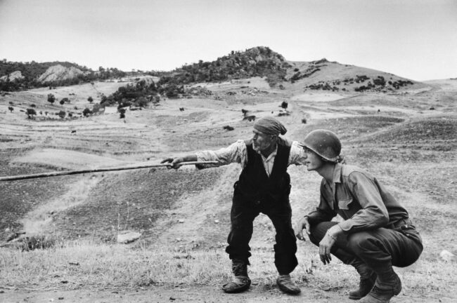 A sicilian peasant telling an American officer which way the Germans had gone, near Troina, Italy, August 1943. Robert Capa_International Center of Photography_Magnum Photos A-sicilian-peasant-telling-an-American-officer-which-way-the-Germans-had-gone-near-Troina-Italy-August-1943.-Robert-Capa_International-Center-of-Photography_Magnum-Photos